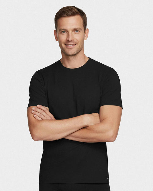 Maison Sarava black cotton crew neck t-shirt with short sleeves on a smiling man with arms crossed.