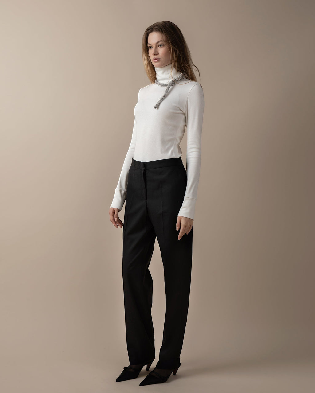Maison Sarava women's black high-waist straight-fit trousers with front patch pockets and A-design stitching detail below the knee.