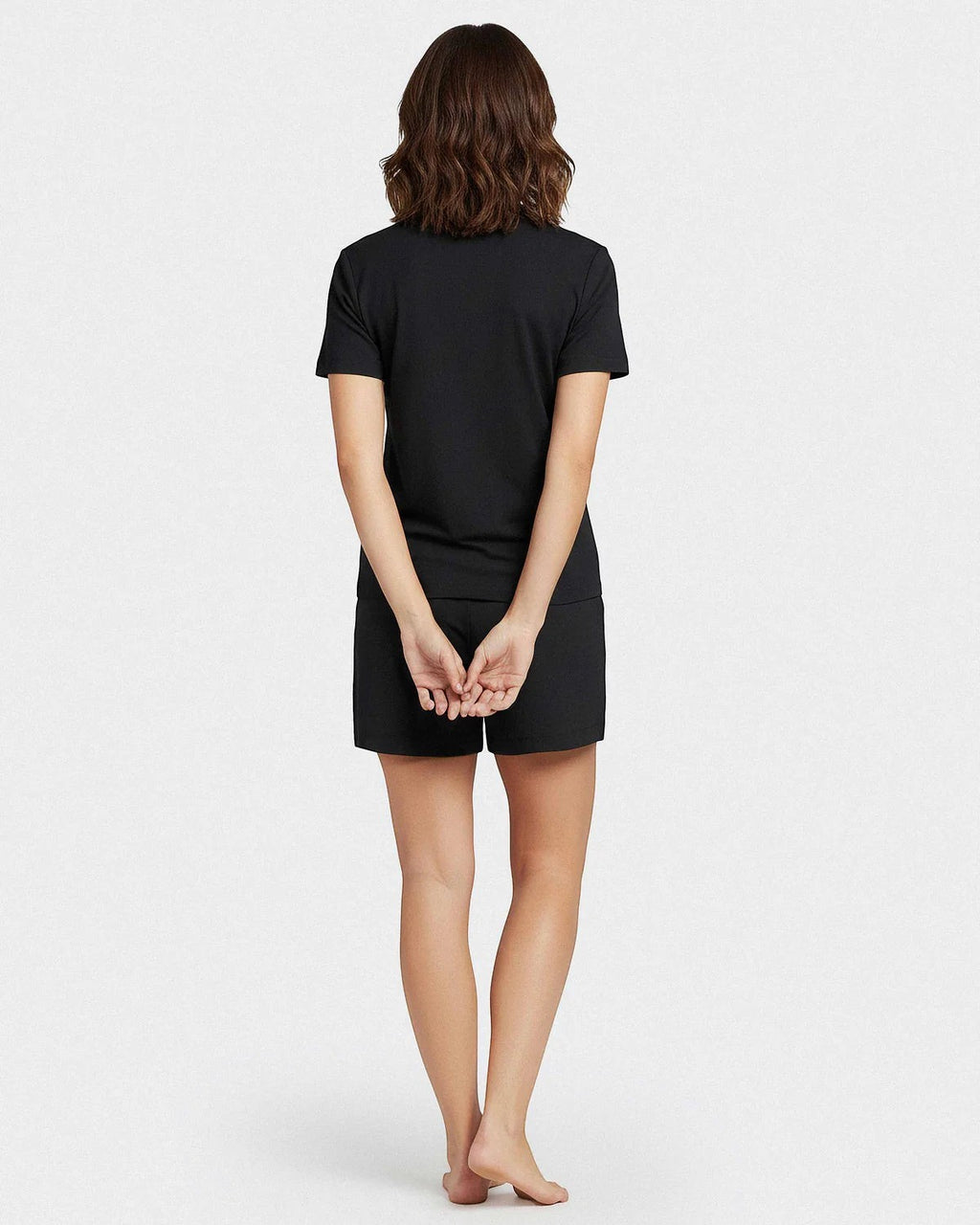Maison Sarava black Lyocell short sleeve V-neck t-shirt and shorts lounge set worn by a woman.