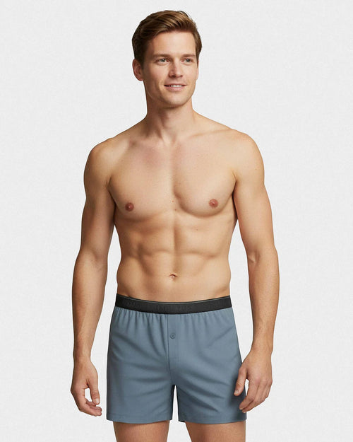 Maison Sarava blue boxer briefs with black waistband and button fly, worn by a man against a white background.