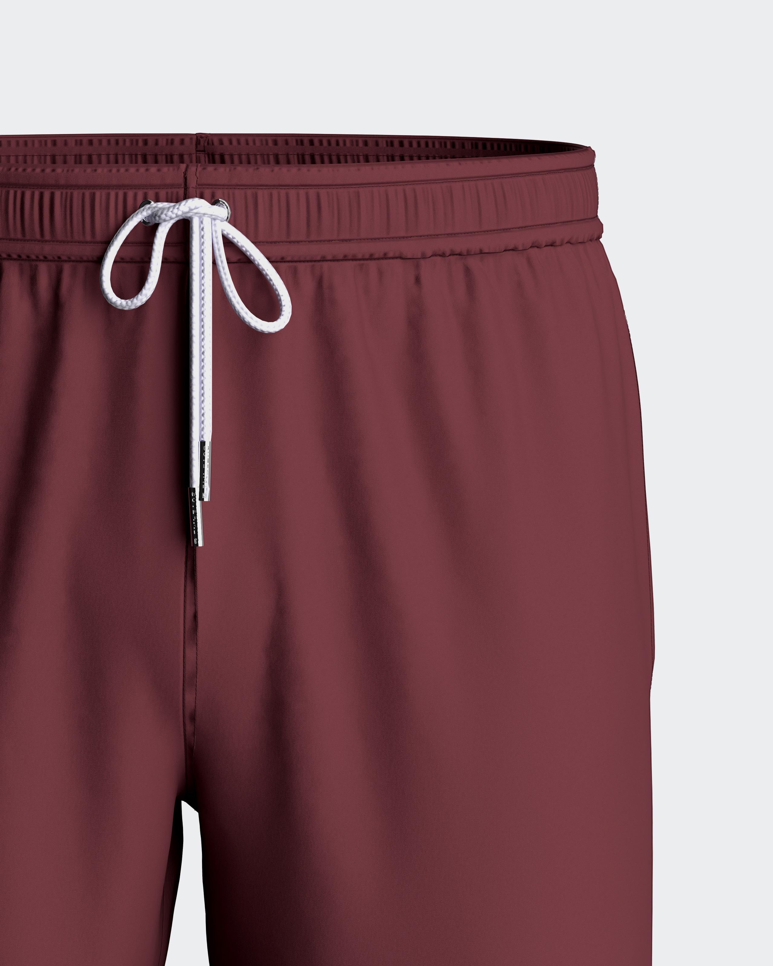 Maison Sarava men's burgundy polyester swim shorts with adjustable drawstring waist and inner mesh lining.