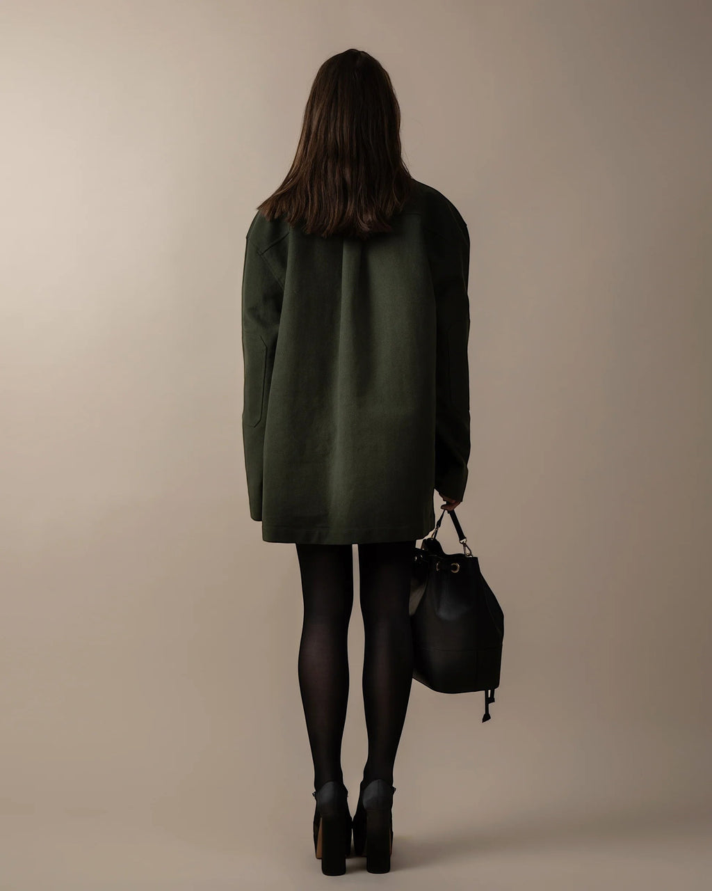 Maison Sarava dark green oversized utility jacket with peaked lapels, raglan sleeves, and patch pockets.