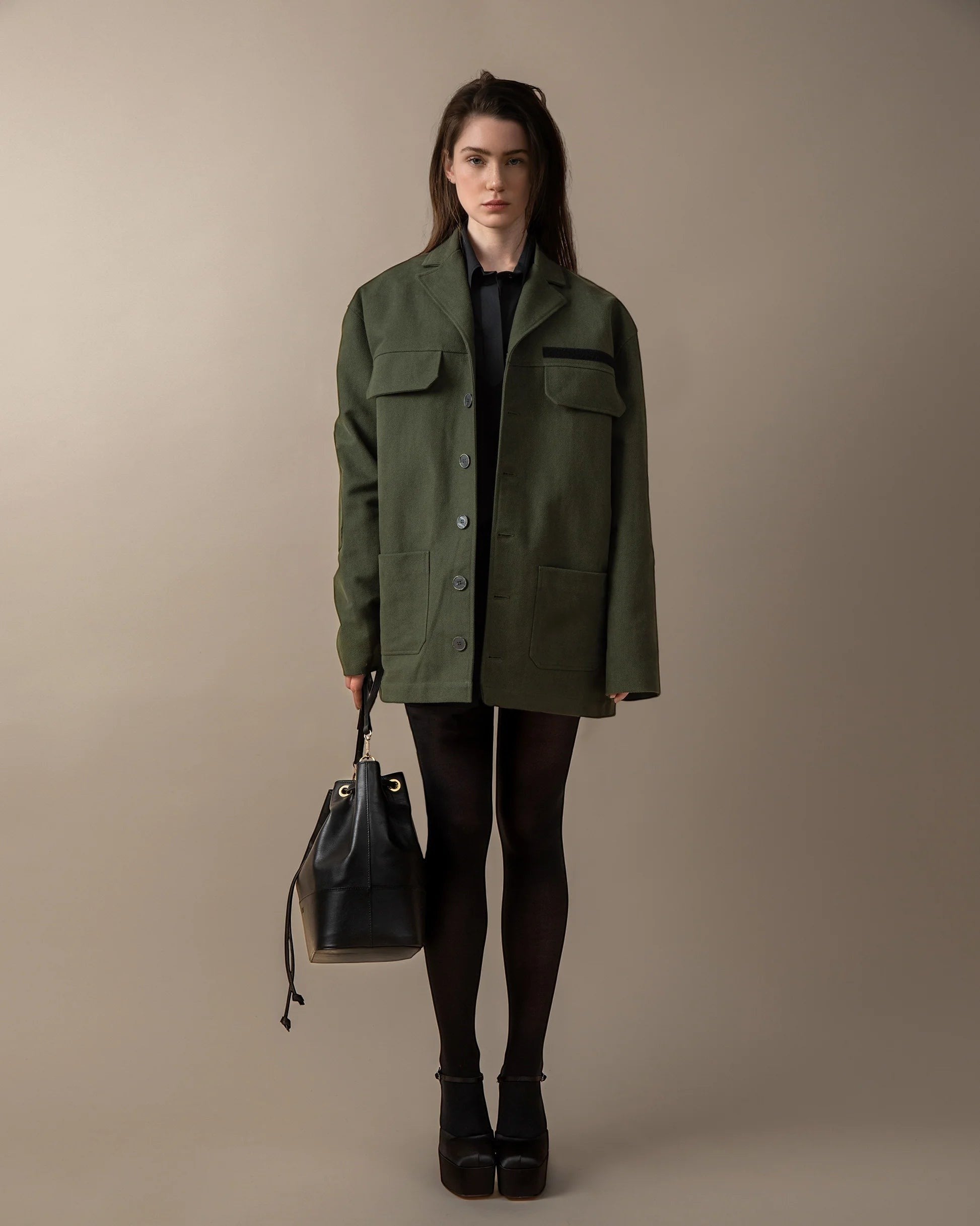 Maison Sarava green oversized utility jacket with peaked lapels, patch pockets, and elbow patches. Unisex design.