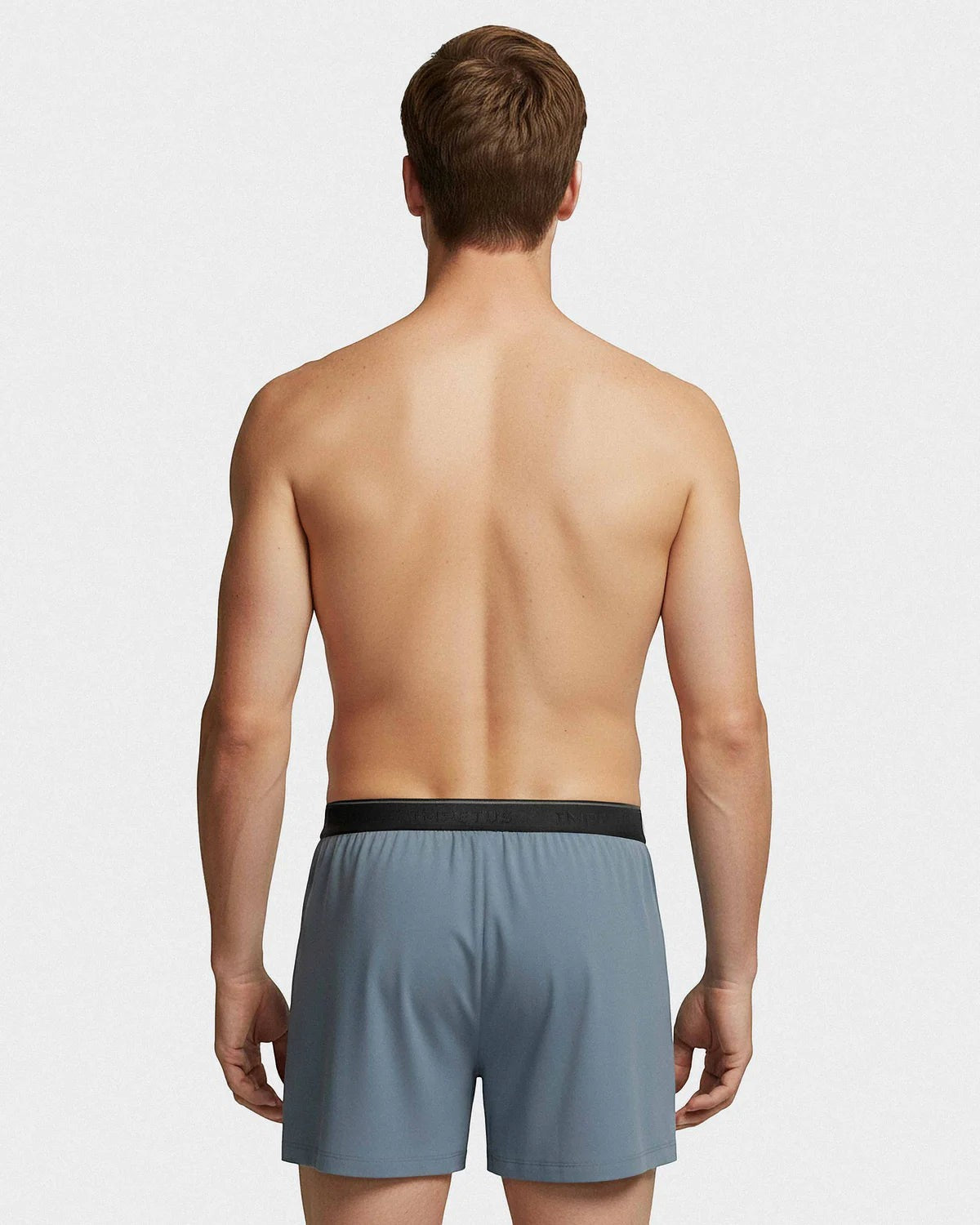 Maison Sarava grey boxer briefs with black branded waistband on a male model from behind.