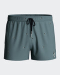 Maison Sarava men's teal swim shorts with tropical micro-motif, elastic waistband, and drawstring.