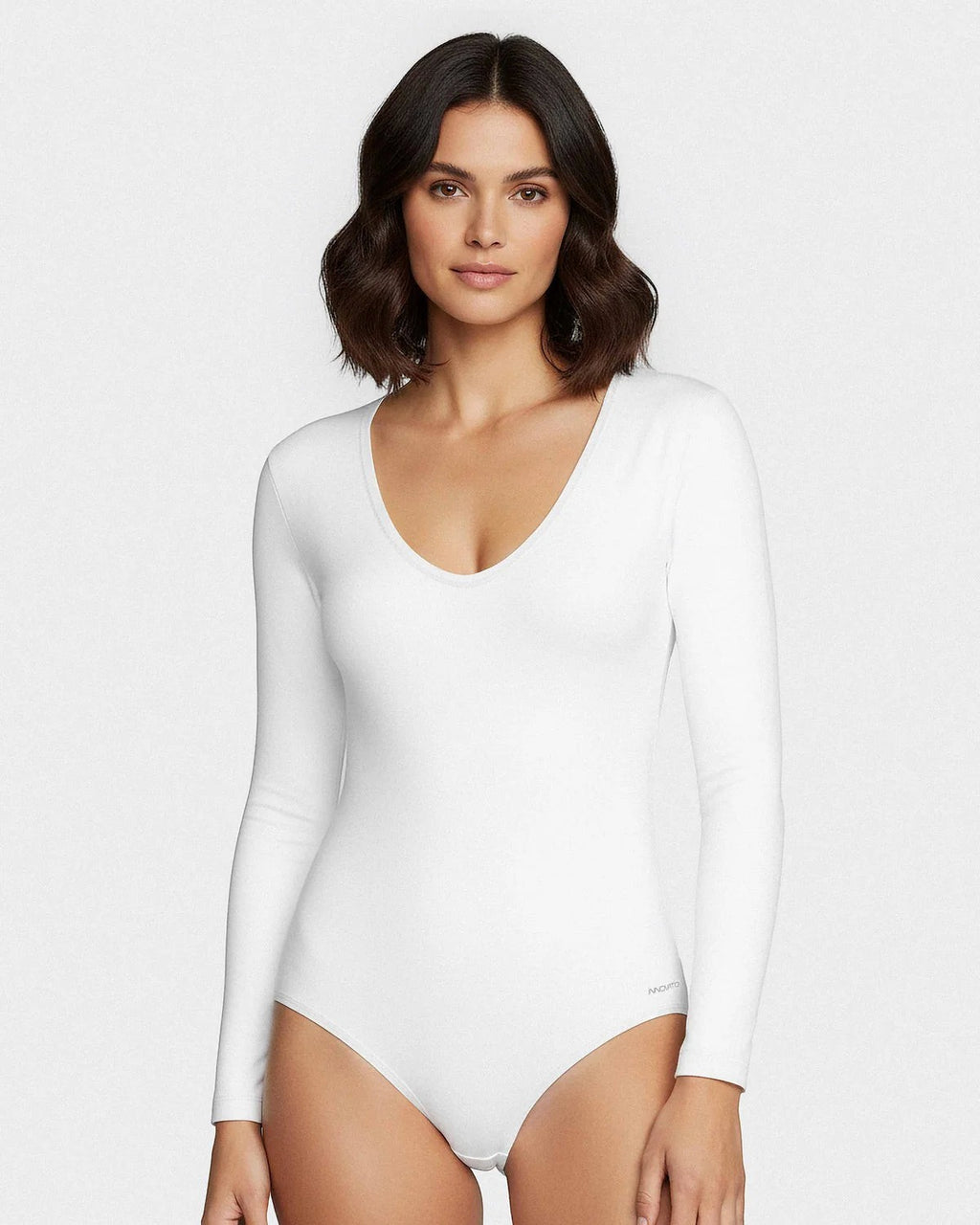 Maison Sarava white long sleeve V-neck bodysuit made from soft, breathable fabric for a smooth, second-skin feel.
